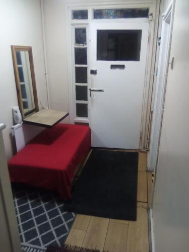 a room with a red couch and a door at Romantic Guest Rooms in London