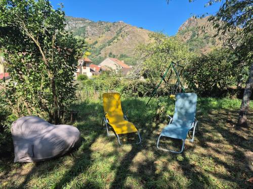two chairs and a swing in the grass at Maison avec jardin aux Cabannes - Ariège in Les Cabannes