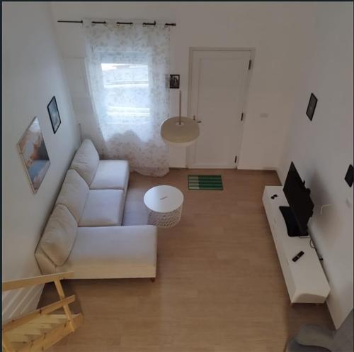 a living room with a white couch and a table at Matī Guest House in Latiano