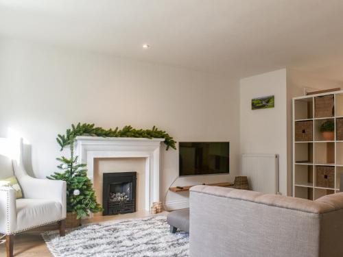 a living room with a fireplace and a tv at Dales Retreat in Skipton