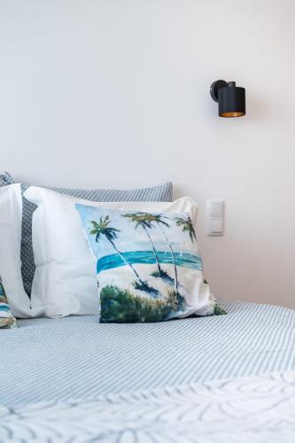 a bed with a pillow on top of it at Na Casa da Fátima in Vila Nova de Milfontes