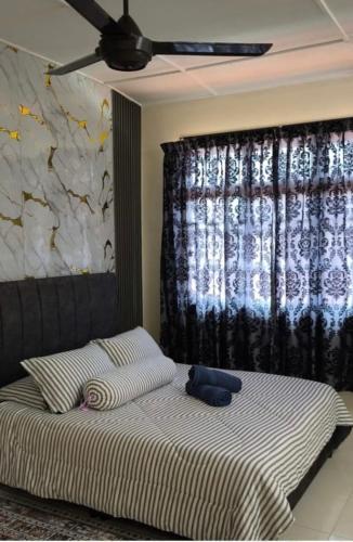 a bed with a teddy bear sitting on top of it at Coach homestay 2 in Kuantan