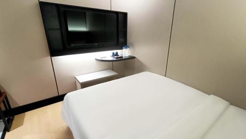 チャンルーンにあるUrban Inn, Changlunのベッドと薄型テレビのある寝室