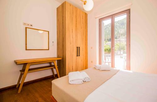 a bedroom with a bed and a table and a window at Mystras 2 Residences Upper and Ground Floor in Mystras