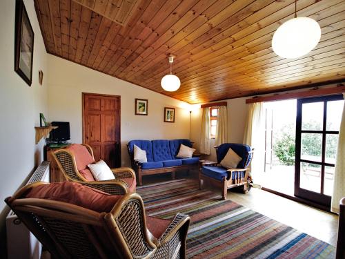 Sea PallingにあるMeadow Viewの青いソファと椅子のあるリビングルーム