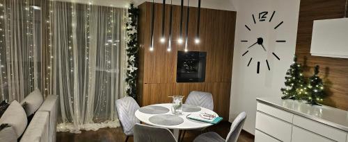 a dining room with a table and a clock on the wall at Apartamenty Prestige Solina in Solina