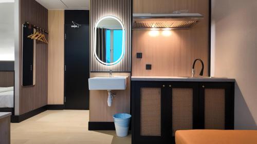 チャンルーンにあるUrban Inn, Changlunの洗面台と鏡のあるバスルーム
