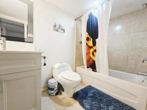 a bathroom with a toilet and a tub and a sink at Garden Ave Suite 3 Mins to Hwy 403 in Brantford