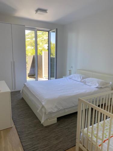 ein Schlafzimmer mit einem weißen Bett und einem Balkon in der Unterkunft Villa Franka 1 in Brela