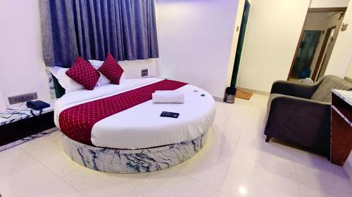 a bedroom with a large bed with red pillows at Smooth Checkin By Edition Blue - Mumbai in Mumbai