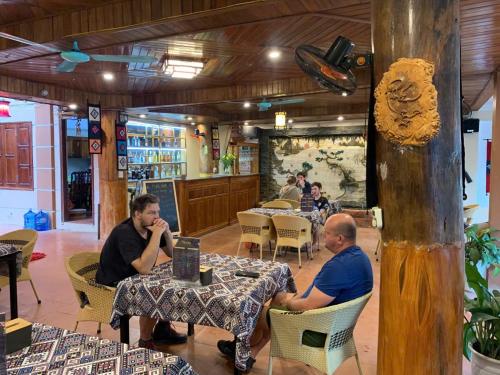 a group of people sitting at tables in a restaurant at Mai Chau Hostel in Mai Chau