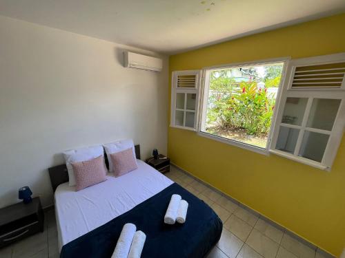 a bedroom with a bed and a window at Villa Loma in Sainte-Rose