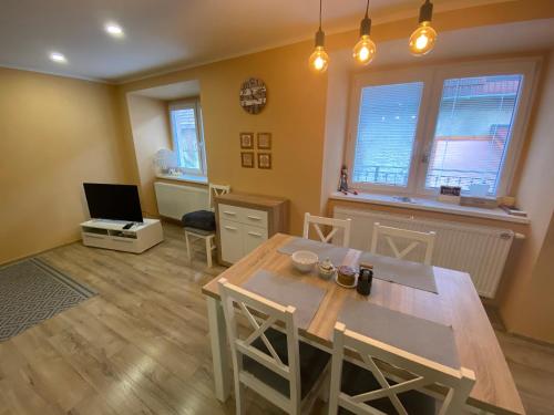 a dining room with a table and chairs and a television at Apartmán u Kuľky in Spišské Bystré