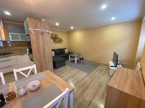 a kitchen and living room with a table and a couch at Apartmán u Kuľky in Spišské Bystré
