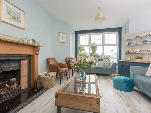 a living room with a couch and a fireplace at Llywnfor in Morfa Nefyn