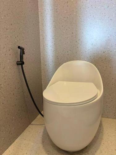 a white toilet in a bathroom with a hose at Aya Beach Resort Koh Lipe in Ko Lipe