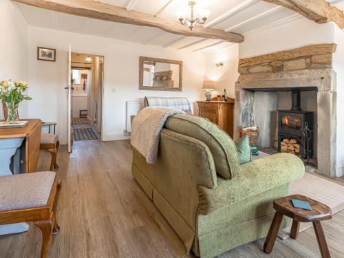 a living room with a couch and a fireplace at Lodge Farm Cottage in Haworth