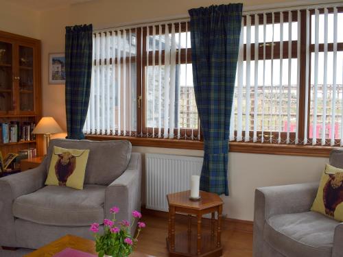 a living room with two chairs and two windows at Quiet in Whauphill