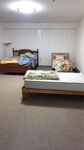 a room with two beds in a room at Minpaku ayu B in Nago