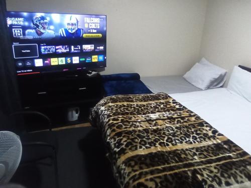 a room with a bed and a flat screen tv at Romantic Guest Rooms in London