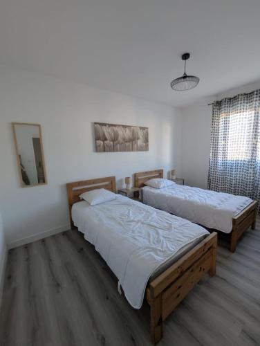 Appartement tout confort - Idéal pour les familles في فوجير: غرفة نوم بها سريرين ومرآة