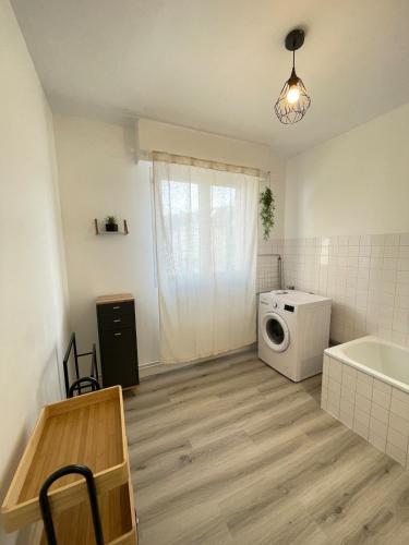 Appartement tout confort - Idéal pour les familles في فوجير: حمام مع غسالة وحوض استحمام