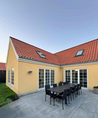 a table and chairs in front of a house at Holiday Home With Courtyard In Lille Skagen in Skagen