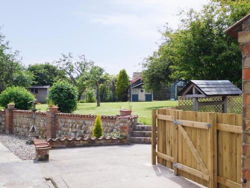 a wooden fence with a wooden gate in a yard at West End Farmhouse in Barmston
