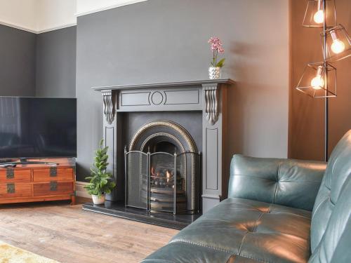 ein Wohnzimmer mit Kamin und Couch in der Unterkunft Ty Isaf in Barmouth