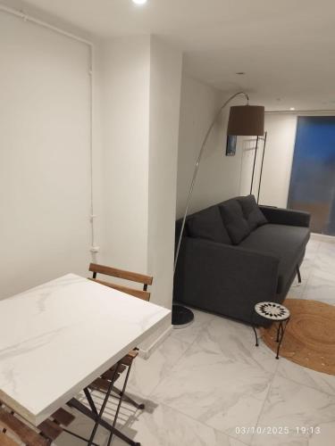 ein Wohnzimmer mit Sofa und Tisch in der Unterkunft Studio à Eckbolsheim proche CV et marché de Noël de Strasbourg in Eckbolsheim