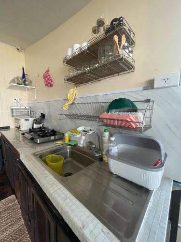 a kitchen counter top with a sink and a kitchenilit at Fisherman's house on stilts Phuket Old Town in Ban Tha Khreng