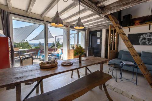 - un salon avec une table en bois et un banc dans l'établissement Appartement au cœur des montagnes, à Métabief