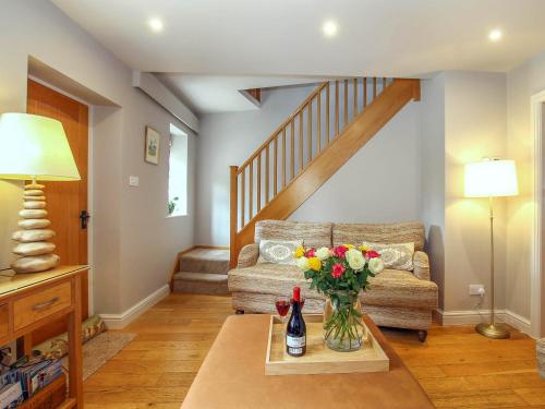 ein Wohnzimmer mit einem Sofa und einer Vase mit Blumen auf dem Tisch in der Unterkunft Pond View Cottage in Brantingham