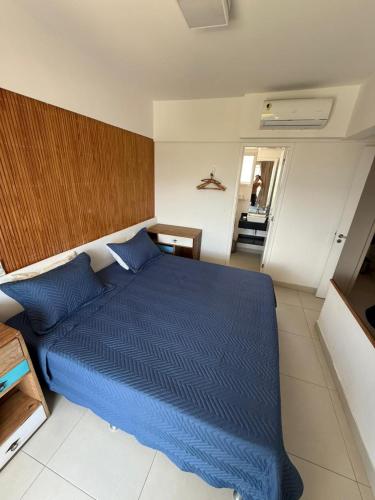 a bedroom with a blue bed and a staircase at Vista Serra e Mar in Bertioga