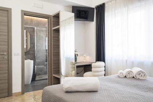 a bedroom with a bed and a bathroom at Talìa Rooms And Gallery in Messina