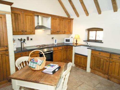a kitchen with wooden cabinets and a wooden table at Groom's Cottage - E5398 in Dunstall