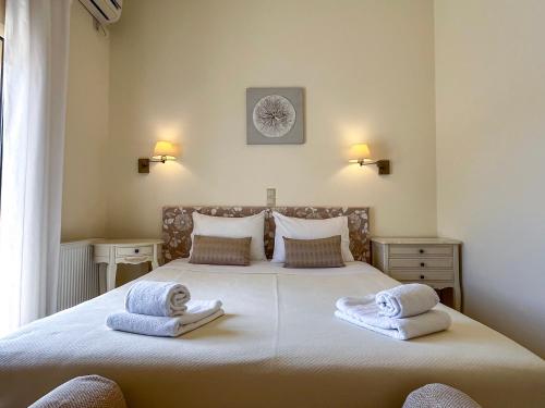 a bedroom with a large bed with towels on it at Sea Breeze - Home with a View in Bouzéïka