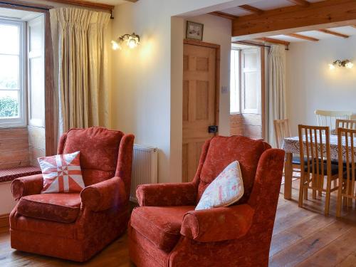 a living room with two chairs and a table at Gunluk Cottage in Brompton
