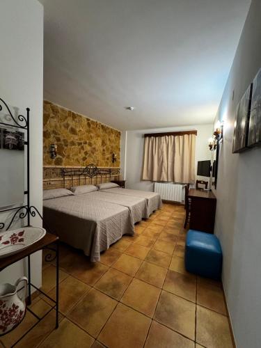 a bedroom with two beds and a table and a window at Hostal Todolella in Todolella