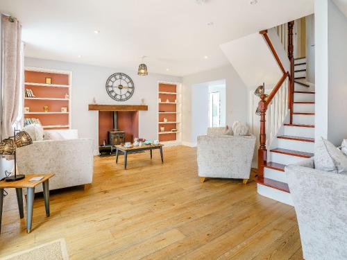 a living room with a clock on the wall at Penlon Cwrws in Llangynllo