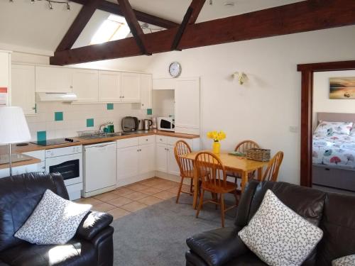 a kitchen and dining room with a table and chairs at Sparrow in Shipton Gorge