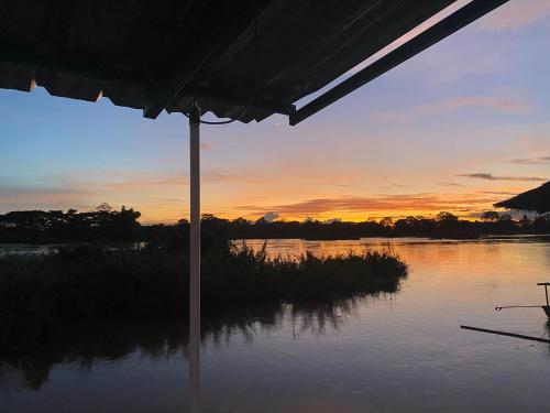 a view of a lake at sunset from an umbrella at Sompong sunset view guest house in Don Det