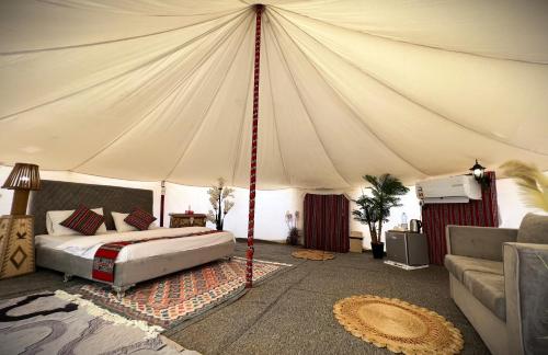 een slaapkamer met een bed in een tent bij Al Salam Desert Camp Oman in Al Qābil