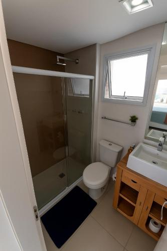 a bathroom with a shower and a toilet and a sink at Vista Serra e Mar in Bertioga