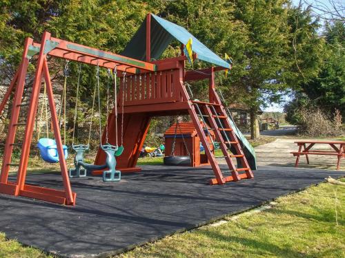 a playground with a slide in a park at Cider Cottage in Hawkchurch