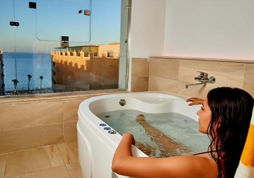 a woman is sitting in a bath tub at Juliana Beach Elite Queen T Collection in Hurghada