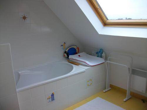 a bathroom with a large tub in a attic at Maison d'Aude in Brignogan-Plage