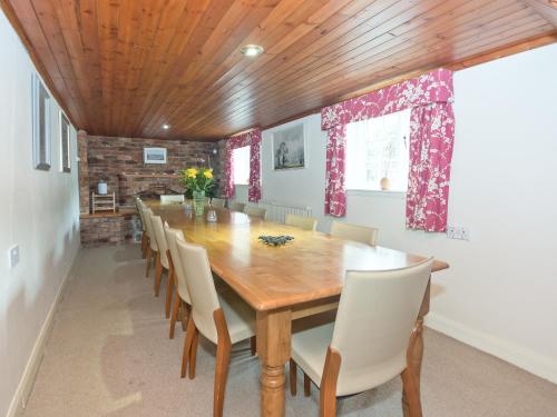 a dining room with a wooden table and chairs at Greenlands Farmhouse in Barmby on the Moor