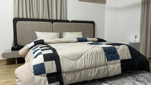 a bedroom with a large bed with a blanket on it at المسارات الدولية in Mawāliḩ