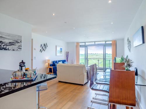 a kitchen and living room with a table and chairs at 7 Cribbar in Newquay